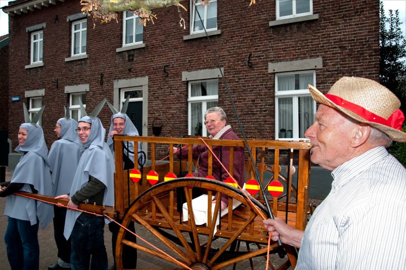 Ezels en ezeldrijver met ‘vracht’ tonen de kar aan het publiek